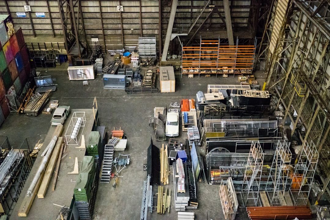 Överblick av en stor industrihall fylld med maskiner, utrustning och material för försäljning.