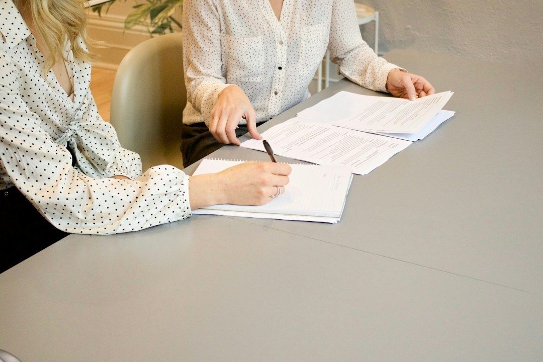 Två personer går igenom löne- och personaldokument vid ett skrivbord